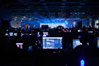 dark event venue filled with gaming personal computers and gamers