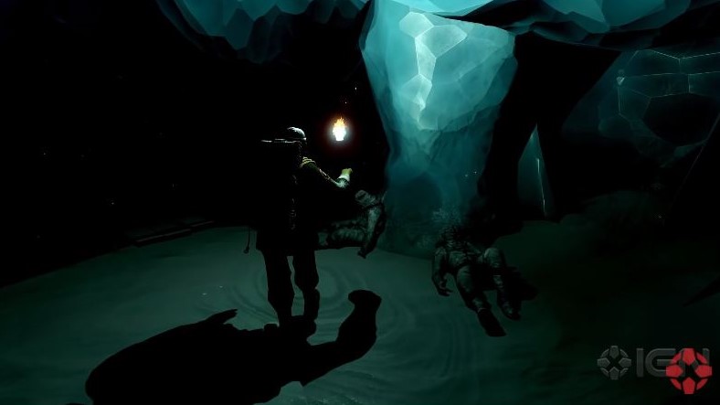player walking inside a dark cave while holding a torch