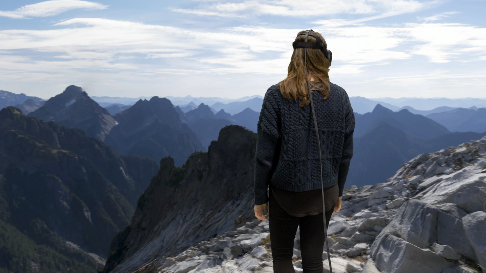 woman standing on the tip of a mountain in free the lab vr game