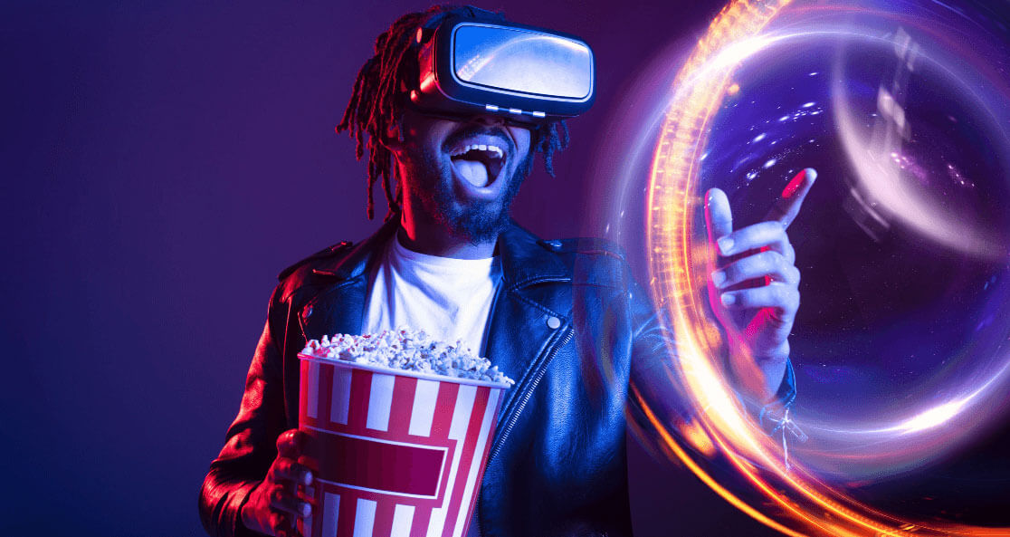 man wearing vr headset and holding a large popcorn bucket while pointing in front