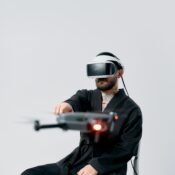 man wearing vr headset and pointing at a drone