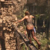 lara croft crossing a thin wood bridge in tomb raider game